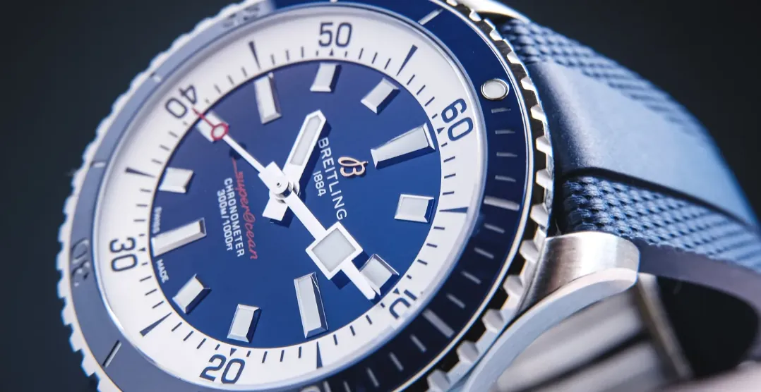 Breitling Superocean dive watch close-up, showcasing the iconic blue dial, high-contrast luminescent indices, unidirectional rotating bezel, and professional diver watch details built for underwater readability and reliability.