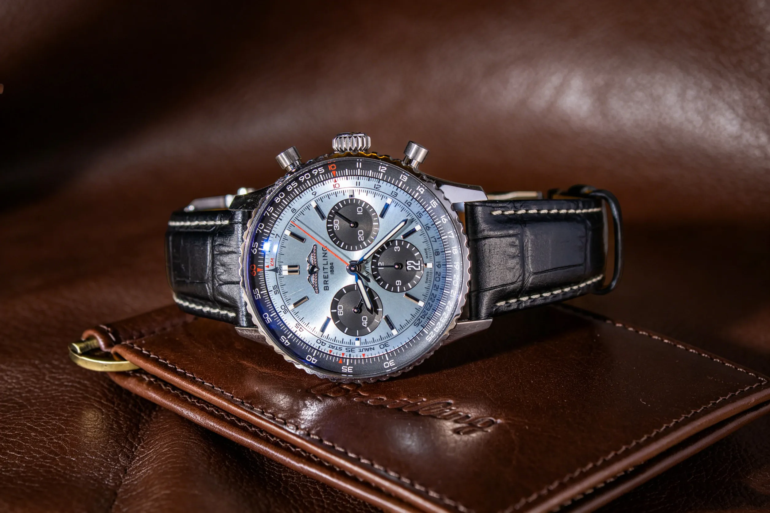 Luxuriöses Lifestyle-Bild des kompakten 41 mm Breitling Navitimer-Replikats, die perfekte Einstiegs-Piloten Uhr für Luftfahrt-Enthusiasten, die neu in den Komplikationen des Rechenschiebers sind. Ausgestattet mit einem hochwertigen schwarzen Alligatorlederarmband, reduziert dieses verkleinerte Modell das Volumen und vereinfacht den äußeren Flug-Rechenschieber für einfaches Lernen von Einheit Umrechnungen und Berechnungen. Während es wöchentliche leichte Reinigung erfordert, um Staub, der in den geschichteten Lücken der Lünette feststeckt, zu entfernen, balanciert seine Vintage-Pilot-Ästhetik formelle und lässige Kleidung, ideal für Sammler, die sich für Luftfahrtgeschichte interessieren und keine geringfügigen routinemäßigen Wartungen scheuen.
