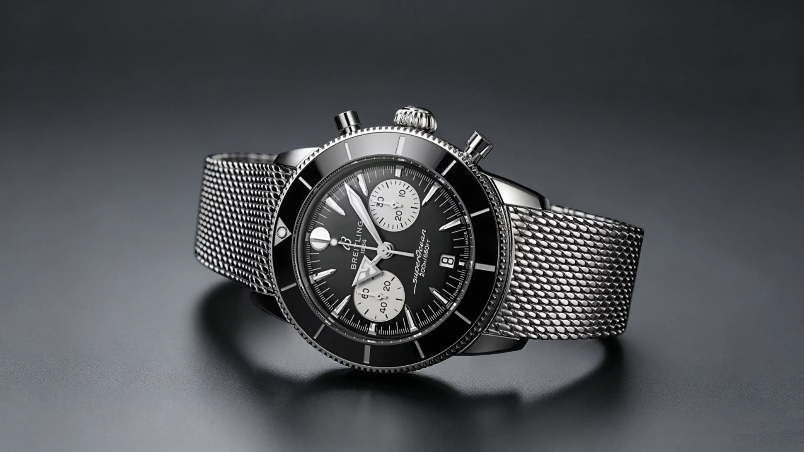 Studio-Produktaufnahme des Breitling Superocean Chronographen-Replikats, ausgestattet mit einem hochwertigen Edelstahl-Mesh-Armband. Dieses taucherorientierte Zeitmessgerät ist das perfekte Einstiegs-Breitling-Replikat für neue Sammler: sauberes leuchtendes Zifferblatt-Layout, benutzerfreundliche einseitige Tauchlünette, ausgewogenes schlankes Gehäuse, das unter Hemdmanschetten passt, hervorragende Wasserbeständigkeit für Schwimmen, Wandern und tägliches Bürotragen sowie ein pflegeleichtes Design mit weniger schwer zu reinigenden Ritzen als bei Rechenschieber-Pilotuhren.