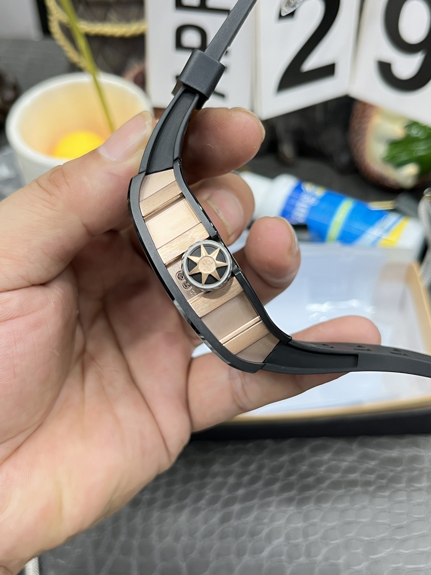 Richard Mille RM Series RM47 black case rose gold mid case black rubber strap samurai armor tourbillon watch handheld side detail view